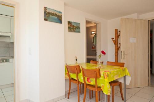 a dining room with a yellow table and chairs at Alpes et Lac in La Neuveville