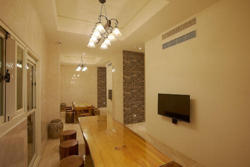 a living room with a table and a television on a wall at 大鵬灣瞭望台 Top Bay B&B in Donggang