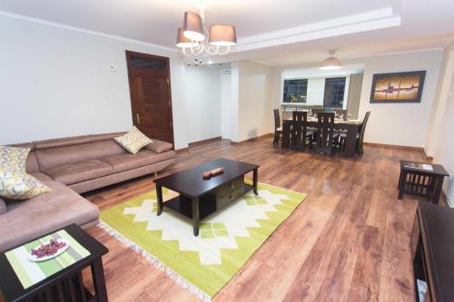a living room with a couch and a table at Cozy Residences by Trianum in Nairobi