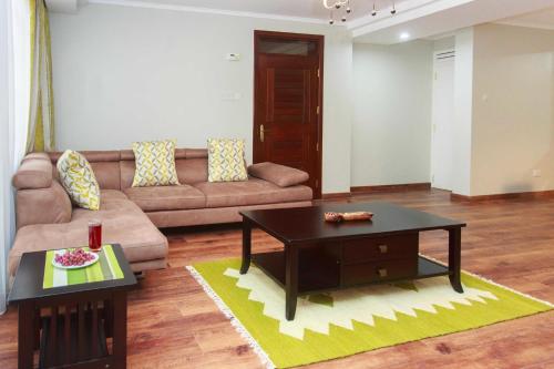 a living room with a couch and a coffee table at Cozy Residences by Trianum in Nairobi