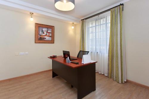 an office with a desk with a computer and a window at Cozy Residences by Trianum in Nairobi