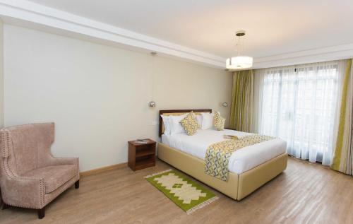 a hotel room with a bed and a chair at Cozy Residences by Trianum in Nairobi