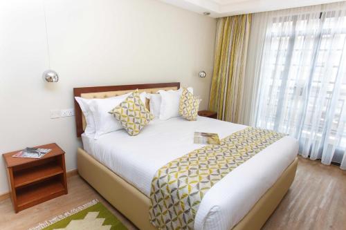 a hotel room with a bed and a window at Cozy Residences by Trianum in Nairobi