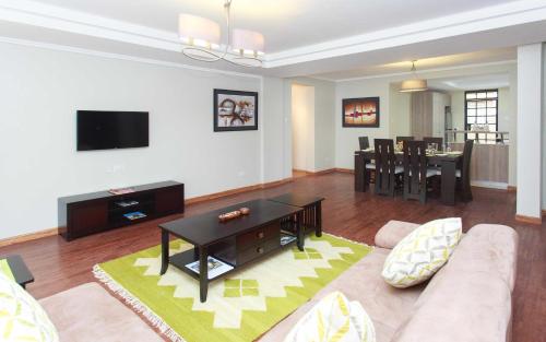 a living room with a couch and a table at Cozy Residences by Trianum in Nairobi