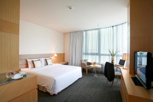 a hotel room with a bed and a television at Liberty Central Saigon Centre Hotel in Ho Chi Minh City