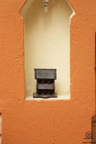 an orange wall with a window in the middle at Aarya Chaitya Inn in Kathmandu