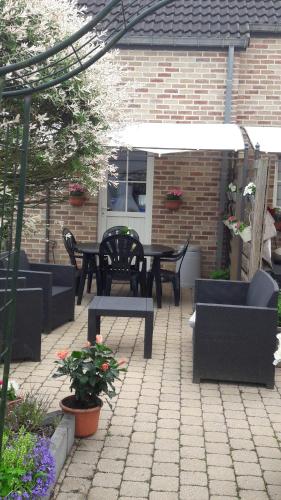 a patio with two tables and chairs and a table and benches at Vakantiestudio Ciney in Chapois