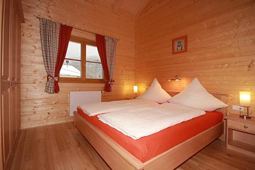 シャルニッツにあるHarrys Hütteの木製の部屋にベッド1台が備わるベッドルーム1室があります。