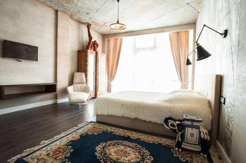 a bedroom with a bed and a large window at Apartment near the sea in Gribovka