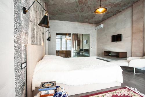 a bedroom with a large white bed and a living room at Apartment near the sea in Gribovka