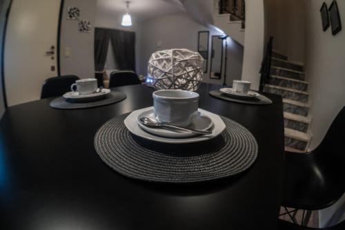 a black table with two cups and saucers on it at Magdalene's Premium Apartments in Ofrínion