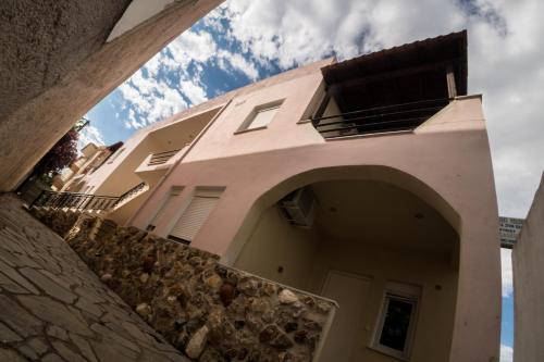 a pink house with an archway in front of it at Magdalene's Premium Apartments in Ofrínion