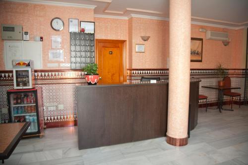 a restaurant with a counter and a pillar in a room at Hostal Niza in San Juan del Puerto