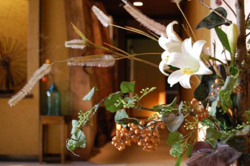 a vase filled with white flowers in a room at Omoideno Jinde in Izu