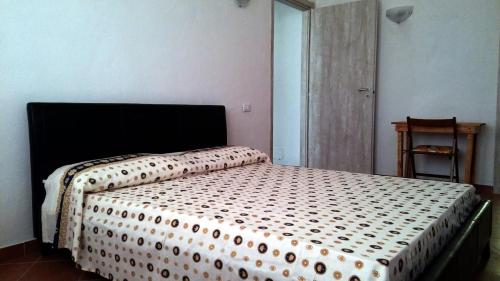 a bedroom with a bed with a black and white comforter at Il Chiosco Giallo in Capalbio