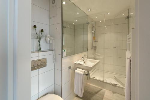 La salle de bains est pourvue d'une douche et d'un lavabo. dans l'établissement Hotel Engel, à Zofingen