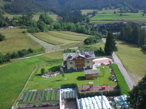 an aerial view of a house on a green field at Agritur Maso Chemela in Cavalese