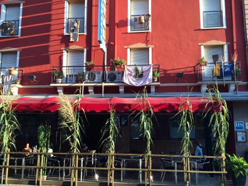a building with a red awning and tables and chairs at Hostal Delgado in Benabarre