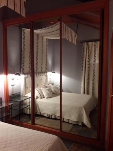 a bedroom with a mirror with a bed in it at ORDINO 2 A in Rascafría