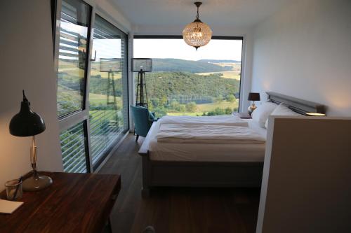 - une chambre avec un lit et une grande fenêtre dans l'établissement Ferienhaus zur Burg Olbruck, à Hain