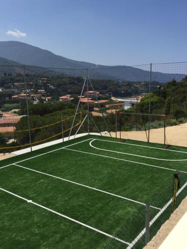 a tennis court with a net on top of it at Hotel La Perla Del Golfo in Procchio