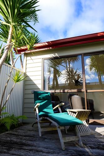 a blue chair sitting on the porch of a house at Tairua Shores Motel in Tairua