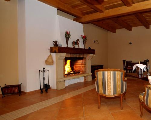 a living room with a fireplace and chairs at Hotelový a jezdecký areál Dvůr Krutěnice in Krutěnice