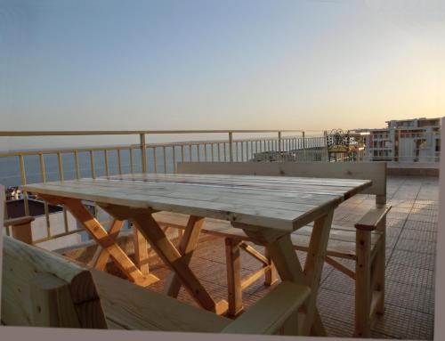 mesa de madera en la parte superior de un balcón en Panoramic Sea View Apartment Crown, Pools and Beach, Sveti Vlas, en Sveti Vlas