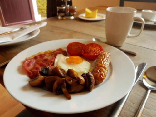 een bord ontbijtproducten met eieren, worst en tomaten bij Old Selden Farm B&B in Worthing