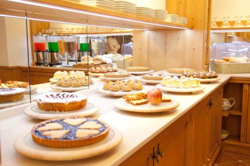 a buffet line with many different cakes and pastries at Hotel Europeo Alpine Charme & Wellness in Pinzolo