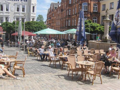 a group of people sitting at tables and chairs at Hotel Frøslev Kro in Padborg