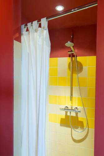 a shower with a white curtain in a bathroom at Strohotel Aalshof in Haps