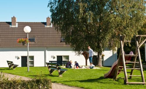 a group of people sitting on the grass in a park at Vakantiewoningen Ons Krijtland in Epen