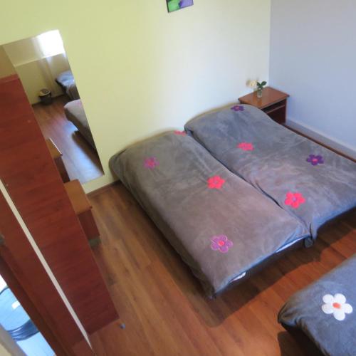 two beds in a room with flowers on them at Tvishi Guest House in Tsʼageri