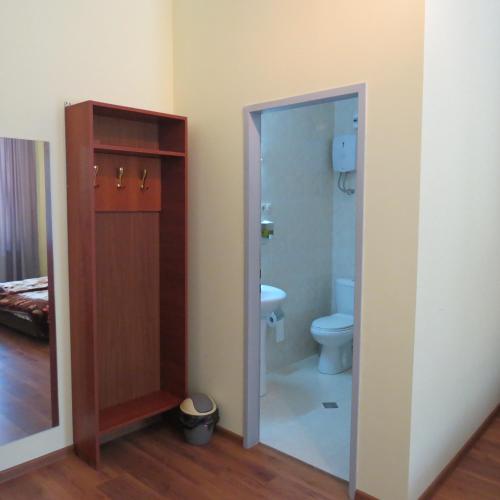 a bathroom with a toilet and a glass door at Tvishi Guest House in Tsʼageri
