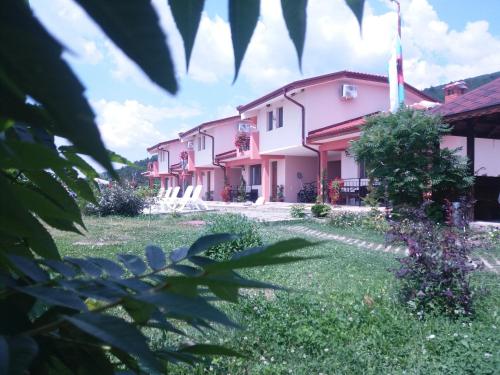 a row of pink buildings with a yard at Gledkata Complex in Skobelevo