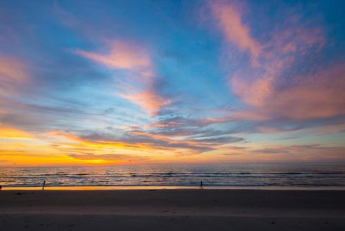 a person walking on the beach at sunset at Sabah Beach Villas & Suites in Kota Kinabalu