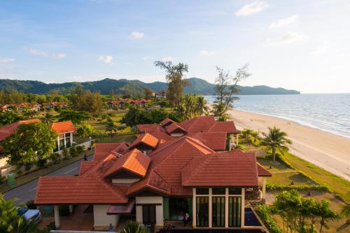 a house with red roofs next to a beach at Sabah Beach Villas & Suites in Kota Kinabalu