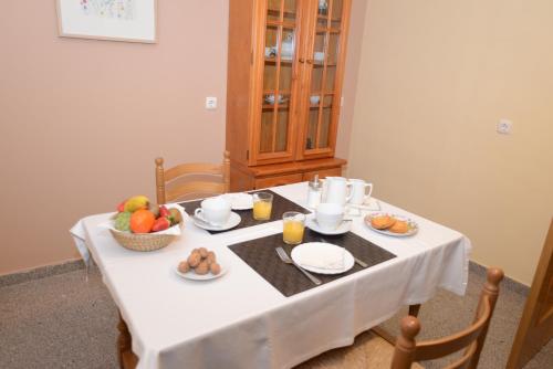 une table avec une nappe blanche et des fruits dessus dans l'établissement Apartamentos Turísticos Ceres, à Mérida