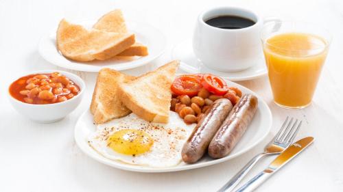 a white plate topped with breakfast foods and a cup of coffee at The Royal & Fortescue Hotel in Barnstaple
