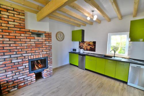 a kitchen with a brick wall and a fireplace at Villa Cis in Darłowo
