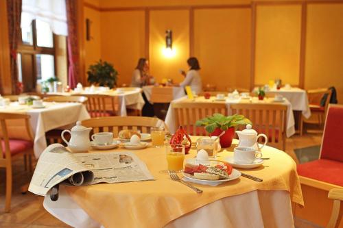 Hotel garni "Zum Eichwerder" في تيمبلين: غرفة طعام مع طاولة عليها طعام