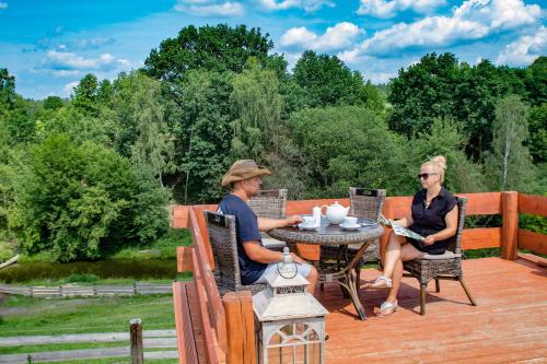 a man and woman sitting at a table on a deck at Rancho Zapotoczny in Łagów