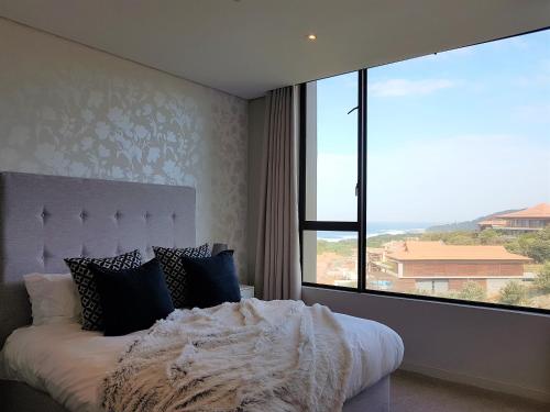 a bedroom with a bed and a large window at Zimbali Suites 507 in Ballito