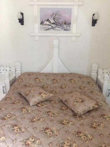 a bedroom with a bed with a painting on the wall at Complex Lions Bucovina in Voronet