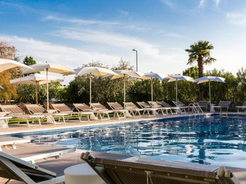 una piscina con sillas y sombrillas en Hotel Ca' Mura en Bardolino