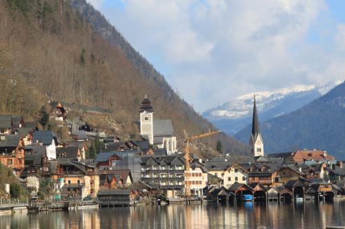 a town on the water with mountains in the background at Mühlradl Apartments Gosau in Gosau