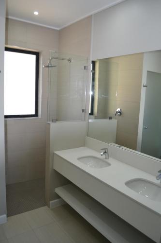 baño con 2 lavabos y espejo grande en Pearl Valley Suite 504 en Simondium