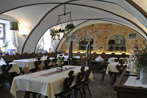 uma sala de jantar com mesas e cadeiras e uma parede de pedra em Hotel Mayerhofer em Aldersbach