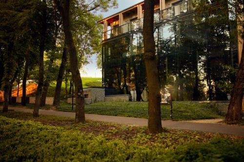 a glass building in the middle of a park at Bristol Art & Medical SPA in Busko-Zdrój